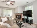 Cozy living room features a fireplace, neutral colors, and natural light through large windows at 8208 Cedar Glen Dr, Charlotte, NC 28212