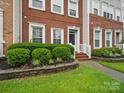 Close-up of brick townhome facade with landscaped front yard and walkway at 9564 Kings Parade Blvd, Charlotte, NC 28273