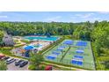 Aerial view of community pool, waterslide, playground, kiddie pool and tennis/pickleball courts at 9800 Walkers Glen Nw Dr, Concord, NC 28027