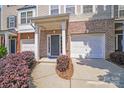 Welcoming townhome entrance with brick accents, attached garage, and manicured landscaping for curb appeal at 9800 Walkers Glen Nw Dr, Concord, NC 28027