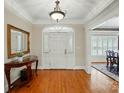 Elegant foyer featuring hardwood floors, a stylish console table with a mirror, and an arched doorway to a dining room at 102 Rosewood Ln, Locust, NC 28097