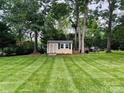 Well-maintained backyard with a storage shed, mature trees, and meticulously striped lawn at 104 Laura Ct, Cherryville, NC 28021