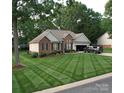 Charming brick home with manicured lawn, attached garage, and inviting curb appeal at 104 Laura Ct, Cherryville, NC 28021