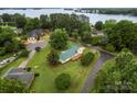An aerial view shows the home with a green roof and lush trees near the water at 105 Pelican Ct, Mooresville, NC 28117
