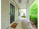 Welcoming covered front porch featuring a dark door, a 'welcome' mat, and a cozy, inviting ambiance at 10732 Trolley Run Dr, Cornelius, NC 28031