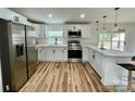 Modern kitchen boasts stainless steel appliances, white cabinets, and a breakfast bar with pendant lighting at 117 Autumn Woods Dr, Kings Mountain, NC 28086