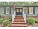Close up shot of the house with brick steps, gray siding, black shutters and black double doors with decorative glass at 1230 Somersby Ln, Matthews, NC 28105