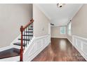 Inviting foyer with hardwood floors, staircase, and elegant wainscoting leading into the living space at 13407 Morgan Lee Ave, Charlotte, NC 28213