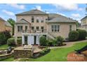 Spacious backyard with a deck, a stone fire pit, and mature landscaping at 13716 Glen Abbey Dr, Charlotte, NC 28278
