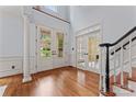 Grand foyer with hardwood floors, staircase, and double doors leading to the outside at 13716 Glen Abbey Dr, Charlotte, NC 28278