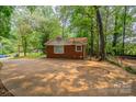 A cozy brick home features a backyard patio and lush green foliage at 1401 Hillwood Ct, Charlotte, NC 28210