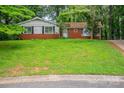 Cozy brick home features black shutters, windows, and a green lawn at 1401 Hillwood Ct, Charlotte, NC 28210