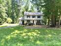 Traditional two-story home framed by mature trees, with a well-manicured lawn at 14027 Hackamore Dr, Matthews, NC 28105