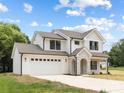 A pristine white two-story home with a stone-accented entrance, a two-car garage, and a well-maintained front lawn at 1490 White Hall Pl, Gastonia, NC 28056