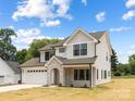 Beautiful two-story home with a stone archway entrance, two-car garage, and green lawn, bathed in sunlight at 1490 White Hall Pl, Gastonia, NC 28056