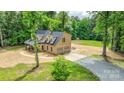 Aerial view of a two-story brick home with an attached garage and ample parking at 15025 Barbee Rd, Stanfield, NC 28163
