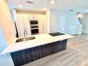 Well-lit kitchen includes an island with a sink, modern appliances, and convenient access to the stairs at 1519 Briar Creek Rd # B, Charlotte, NC 28205