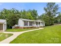 Single-story home with a metal roof, covered porch and sidewalk at 1983 Burkin Rd, McConnells, SC 29726
