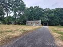 Quaint single-story home with a long driveway and mature trees providing ample shade at 2070 Stirewalt Rd, China Grove, NC 28023