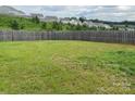 Large, grassy backyard enclosed by a wooden fence, perfect for recreation at 211 Hidden Lakes Rd, Statesville, NC 28677