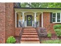Inviting front porch with brick steps, black railings, and a decorative wreath on the front door at 2301 Seth Thomas Rd, Charlotte, NC 28210