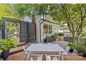 Beautiful backyard deck showcasing an outdoor dining area, complemented by mature trees and stylish landscaping at 2424 Cumberland Ave, Charlotte, NC 28203
