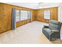 Cozy living room with wood paneling, two large windows, and a comfortable blue armchair at 271 Nc 16 N Hwy, Taylorsville, NC 28681