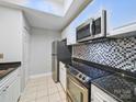 Bright kitchen with stainless steel appliances, granite countertops, and mosaic tile backsplash at 300 W 5Th St # 339, Charlotte, NC 28202