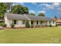 Charming one-story home with brick exterior, lush lawn, and rocking chair front porch at 309 Ogden Dr, Gastonia, NC 28056