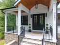 Inviting front porch with a double-door entry, stone accents, and decorative greenery at 3601 Woody Grove Ln, Charlotte, NC 28210