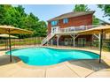 A backyard oasis featuring a large in-ground pool, a patio with umbrellas, and a fenced-in area at 4712 Amberside Dr, Rock Hill, SC 29732