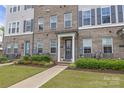 View of the townhome with well-maintained lawn and hardscaped walkway at 5060 Harrowsmith Ln, Charlotte, NC 28204