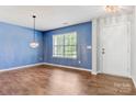 Living room with new flooring, modern chandelier, and a bright window with great natural light at 5311 Oakdale Ridge Rd, Charlotte, NC 28216