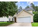 Two-story home featuring light yellow siding, a front lawn, and a two-car garage at 6229 Sid Crane Dr, Charlotte, NC 28216