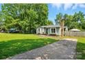 Single story house with a well-manicured lawn and long driveway at 6718 Pueblo Ln, Charlotte, NC 28227