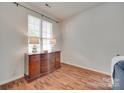 Neutral-toned bedroom with hardwood floors, a window, and a traditional wooden dresser at 727 Torrey Pines Ln, Fort Mill, SC 29715