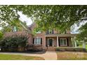 Beautiful brick home featuring black shutters and a covered porch at 8409 Olde Stonegate Ln, Mint Hill, NC 28227