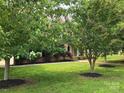 Well-manicured lawn and landscaping highlight this stately brick home's curb appeal at 8409 Olde Stonegate Ln, Mint Hill, NC 28227
