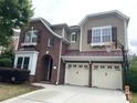 Charming two-story brick and siding home with a two-car garage and basketball hoop over the driveway at 9429 Ridgeforest Dr, Charlotte, NC 28277