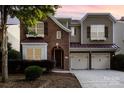 Charming two-story home featuring a two-car garage, brick facade, and meticulously landscaped front yard at 9429 Ridgeforest Dr, Charlotte, NC 28277
