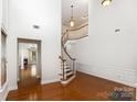 A grand foyer with hardwood floors, soaring ceilings, a gracefully curved staircase, and ample natural light at 9429 Ridgeforest Dr, Charlotte, NC 28277