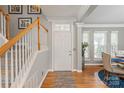 Inviting foyer featuring hardwood floors, a staircase, and soft gray walls, offering a warm welcome at 10924 Owl Nest Ln, Charlotte, NC 28277