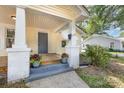 Inviting front porch with painted columns, flowers, and a gray door at 1112 Concord Ave, Monroe, NC 28110