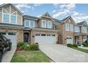 Charming townhouse featuring a stone facade, two-car garage, and well-maintained landscaping at 1126 Roderick Dr, Fort Mill, SC 29708
