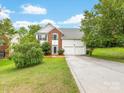 Exterior view of the home with two-car garage, brick facade and well manicured lawn at 12529 Old Timber Rd, Charlotte, NC 28269
