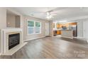 An open concept living room with a fireplace and modern gray flooring flowing to the kitchen at 13413 Golden Apple Ct, Charlotte, NC 28215