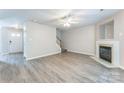 Spacious living room with a fireplace, gray floors, a staircase, and neutral wall paint at 13413 Golden Apple Ct, Charlotte, NC 28215