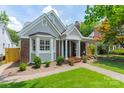 Charming house featuring brick accents, gray siding, and inviting front porch with classic rocking chairs at 2021 Charlotte Dr, Charlotte, NC 28203