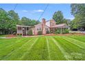 Beautiful brick home with a spacious lawn, covered patio, and additional covered parking at 211 Drive Inn Rd, Locust, NC 28097