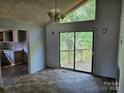 Dining area with sliding doors leading to a deck, featuring a view of the wooded backyard at 211 Putnam St, Shelby, NC 28152
